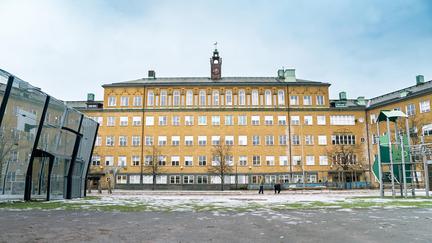 En stor skolbyggnad med ett klocktorn på toppen.