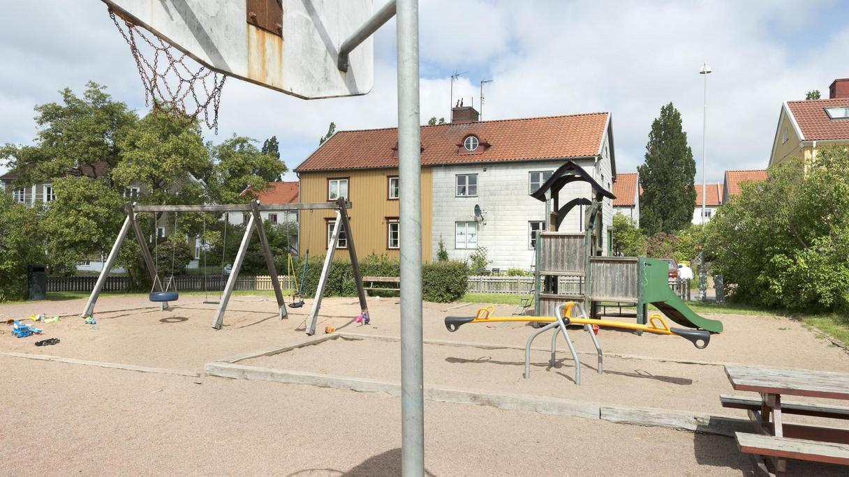 Stor sandyta med bland annat en basketkorg, gungbräda och rutschkana.