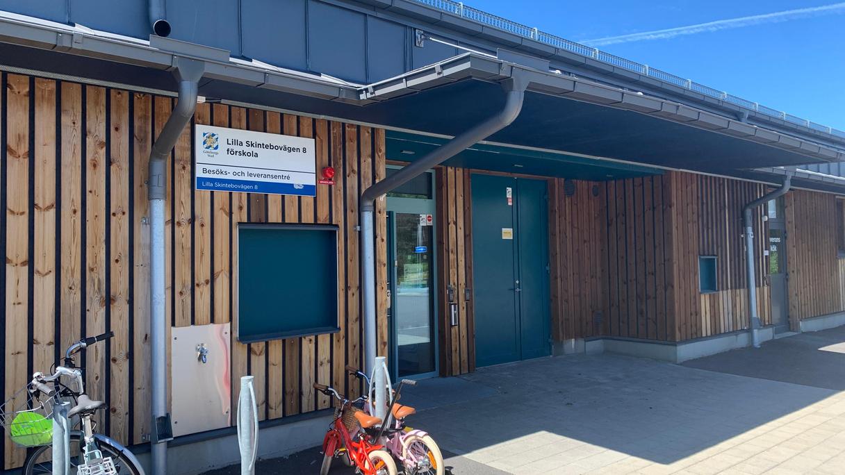 Ingång till träbyggnad med barncyklar framför.