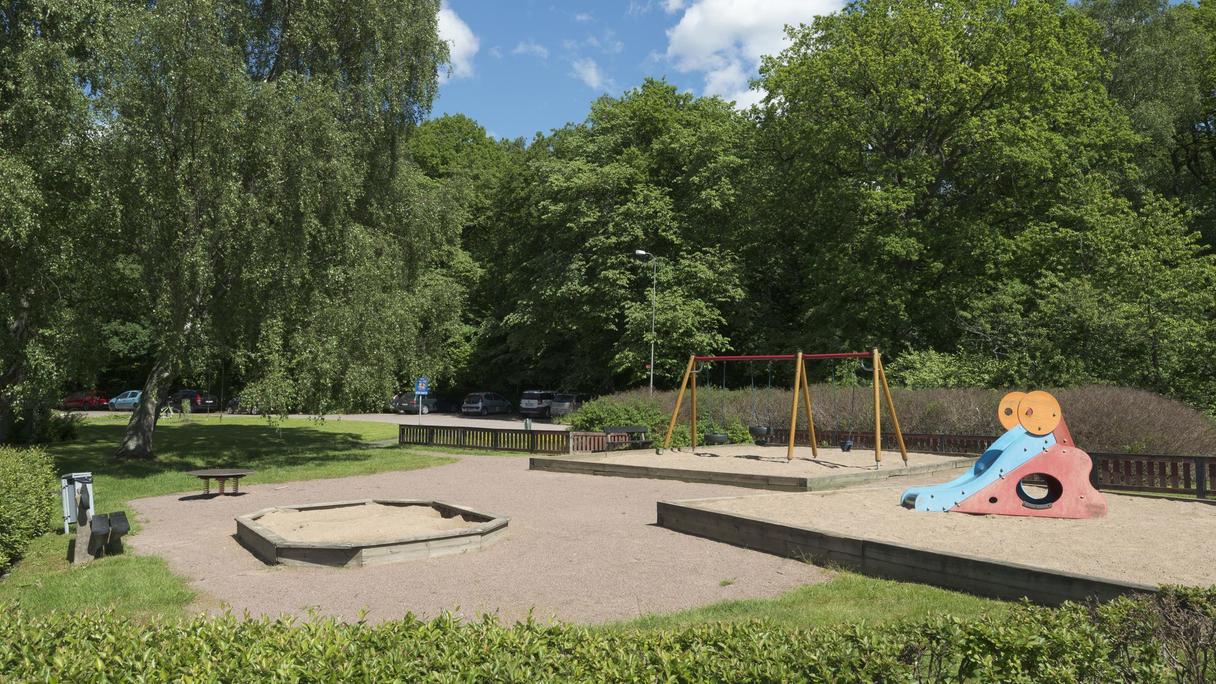Flera sandlådor med bland annat en gungställning och en liten rutschkana.