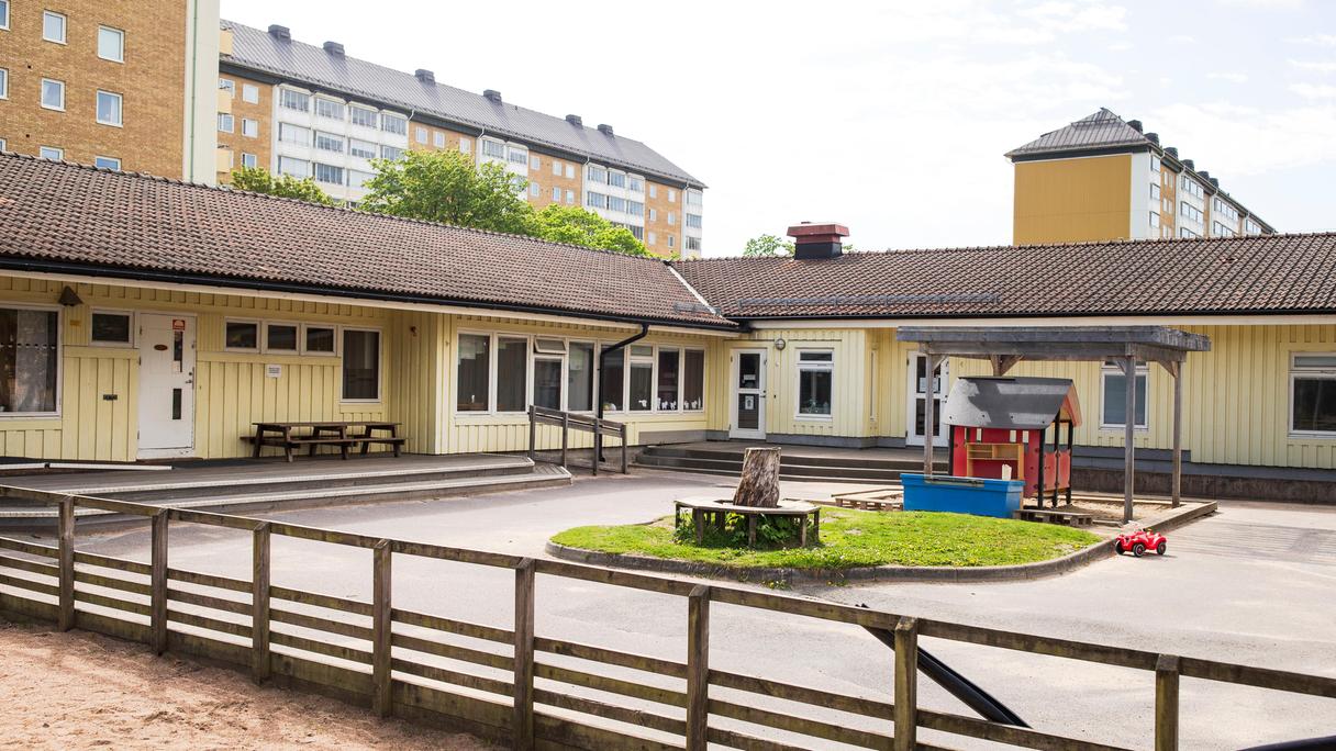 Gul enplansbyggnad med lekplats framför