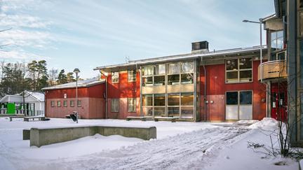 Nytorpsskolans skolgård med några bänkar och träd i bakgrunden.