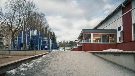 En gågata med multiarena på ena sidan och en skolbyggnad på andra sidan.
