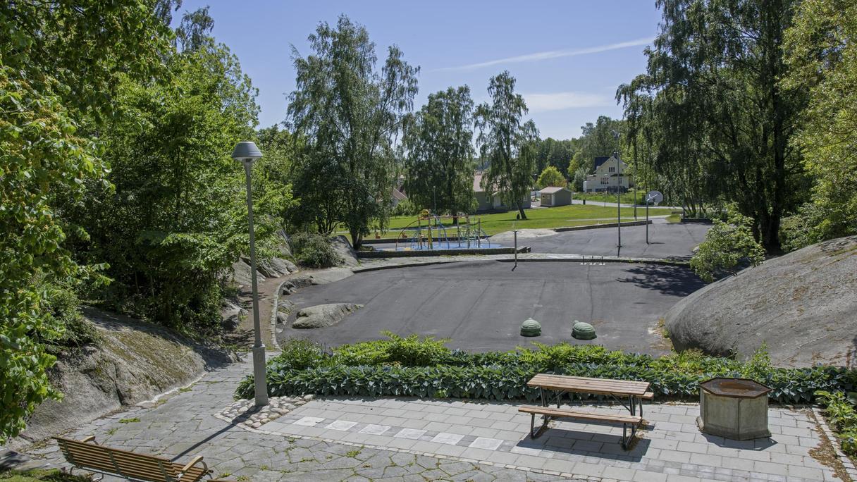 Yta av asfalt och gummiasfalt med bollplaner och klätterställning. 