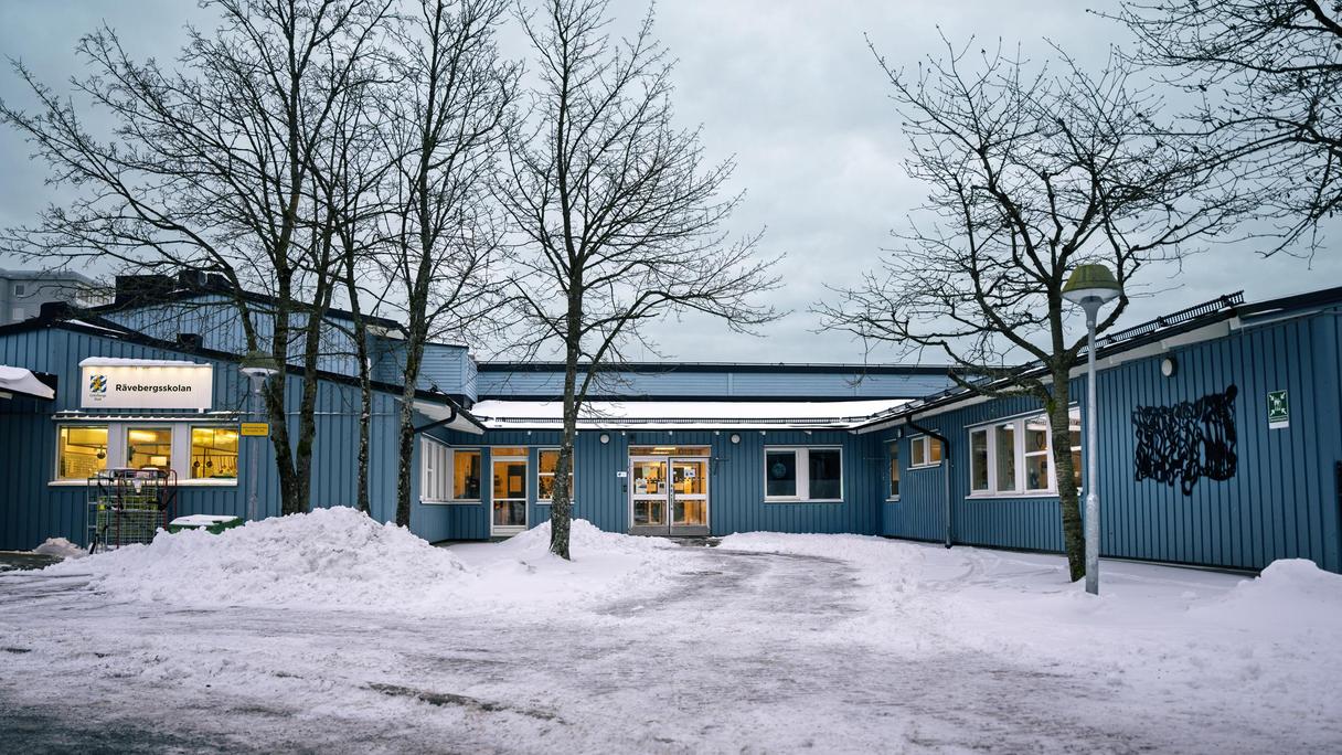 Rävebergsskolans huvudbyggnad med några träd i bakgrunden.