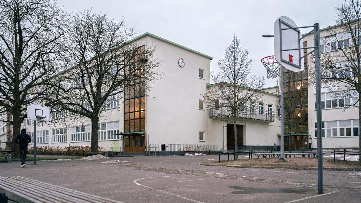 Sannaskolans skolgård men en basketplan och några skolbyggnader i bakgrunden.