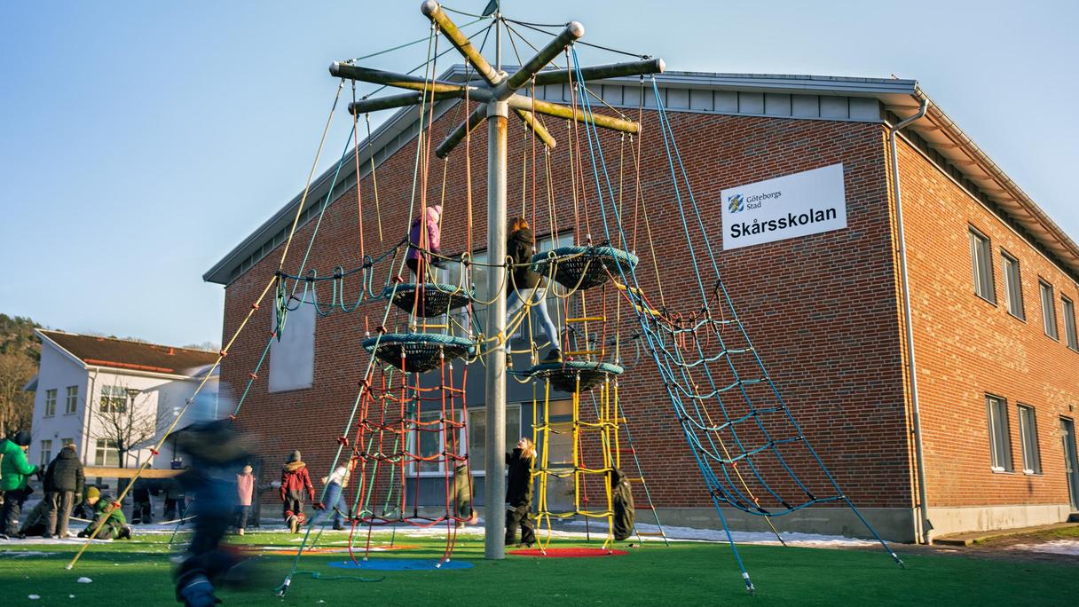 Skårsskolans skolgård med en klätterställning i fokus.