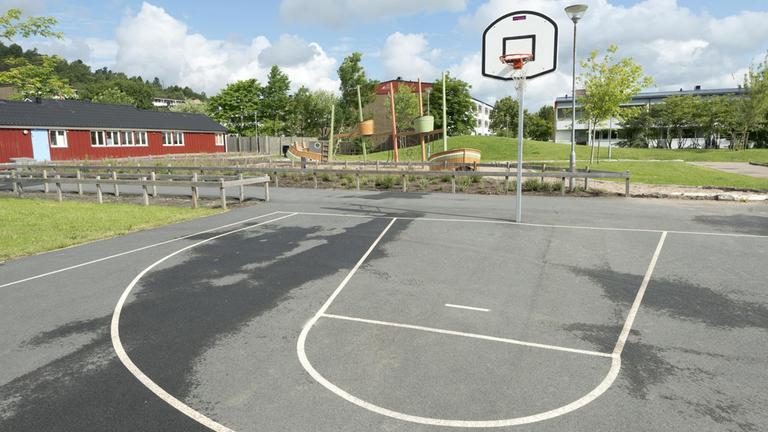 Basketplan och ett lekskepp som står i sand.