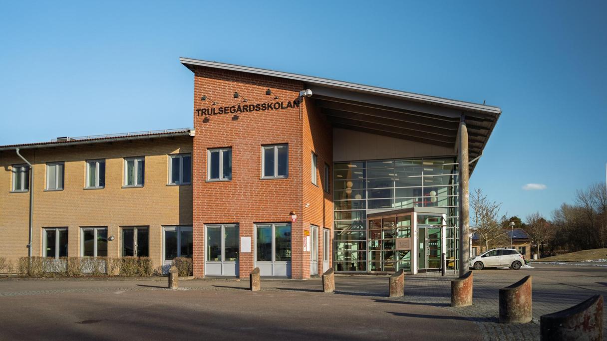 En skolbyggnad i gult och orange tegel och en stor glasad entré