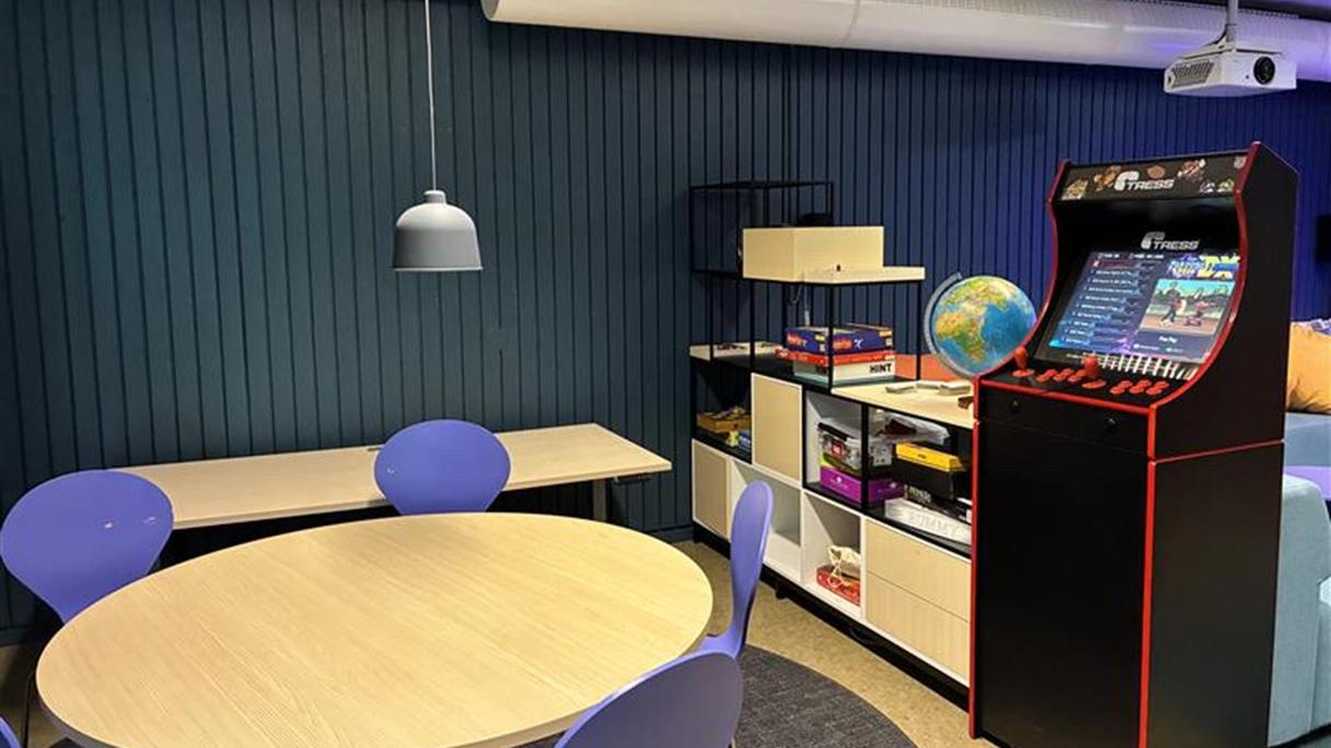 Ett runt bord med stolar. En spelsmaskin