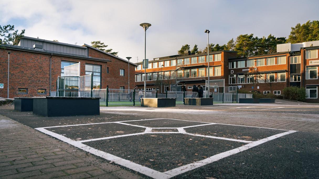 En skolgård framför en skolbyggnad i tegel.