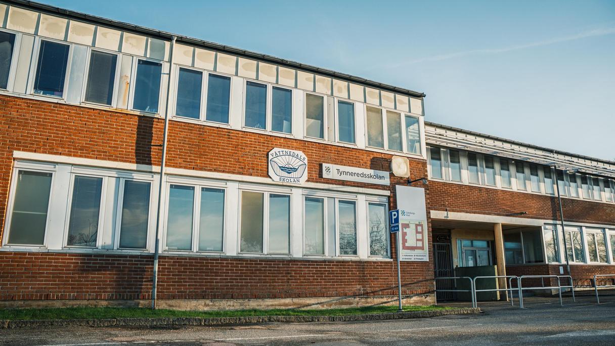 Vättnedalsskolans huvudbyggnad med skolans skylt i fokus.