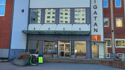 En glasad entré till mötesplatsen i ett röd-vitt hus