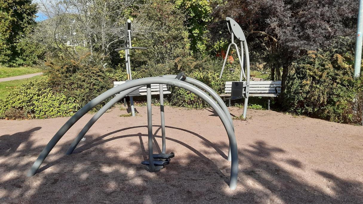 Utegym med tre maskiner på grusad yta