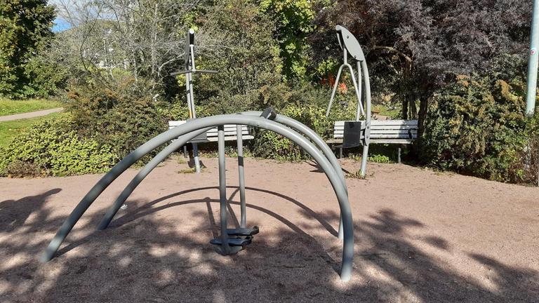 Utegym med tre maskiner på grusad yta