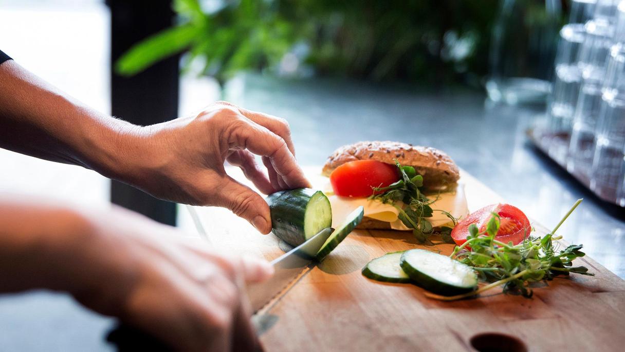 Händer som förbereder en smörgås