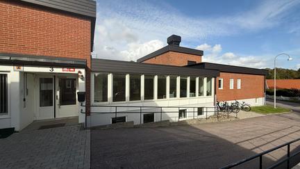 Entrén till Byalagsgatans korttidsboende, röd tegelfasad.