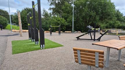 Redskap i grå och grön metall på en grusplan.