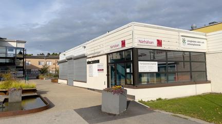 En vit entré på torget. Ingången är där det står "Närhälsan"