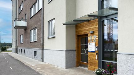 En husfasad intill en cykelbana. Det står nummer 12 tydligt vid entrén.