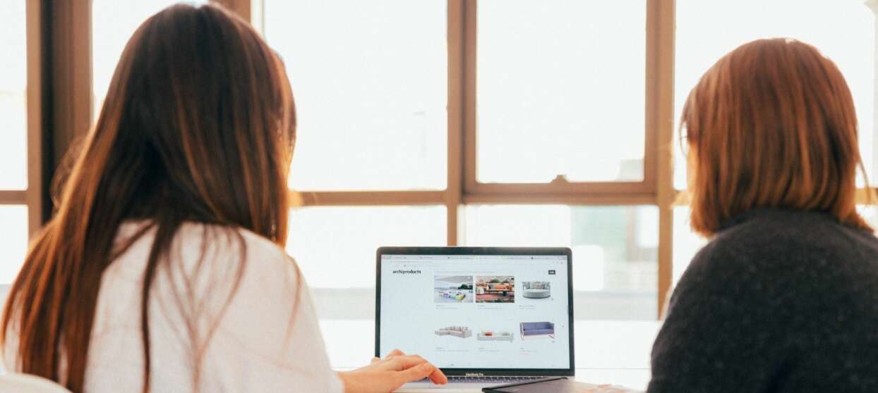 Two women in front of computer 1920x860