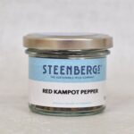 Front photo of Steenbergs Red Kampot Pepper in a jar with silver lid and label.